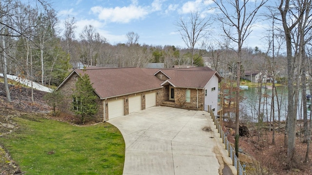 ranch-style home featuring a front lawn, a water view, and a garage