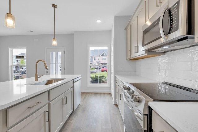 kitchen featuring sink, hanging light fixtures, tasteful backsplash, and stainless steel appliances