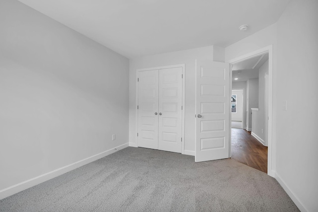 unfurnished bedroom with a closet and carpet flooring