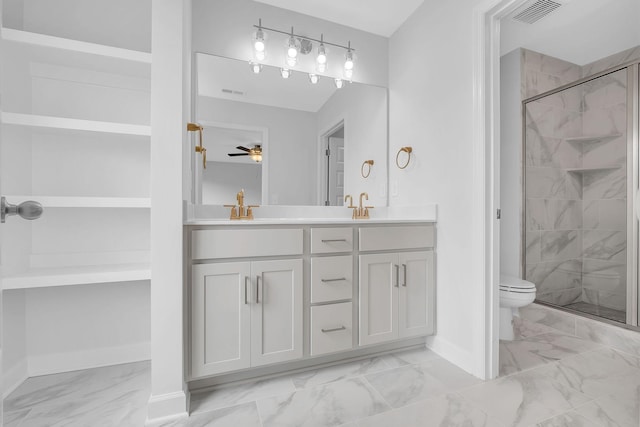 bathroom featuring ceiling fan, vanity, a shower with door, and toilet