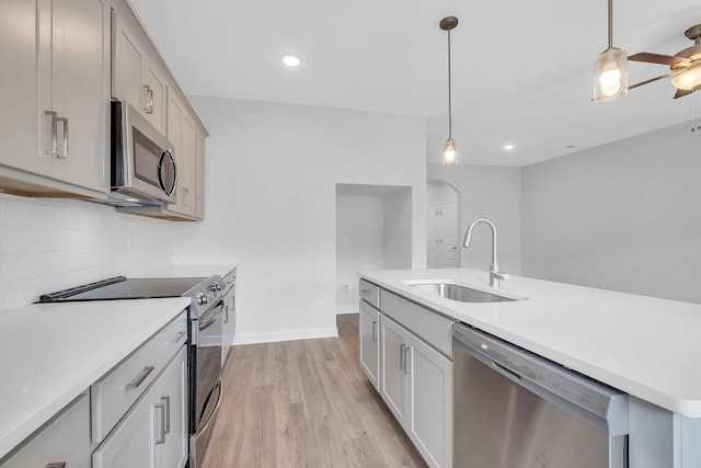 kitchen with sink, appliances with stainless steel finishes, gray cabinets, and tasteful backsplash