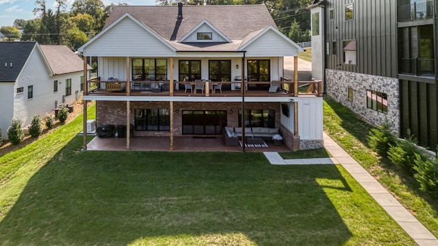 rear view of house featuring a yard, a patio, and an outdoor living space