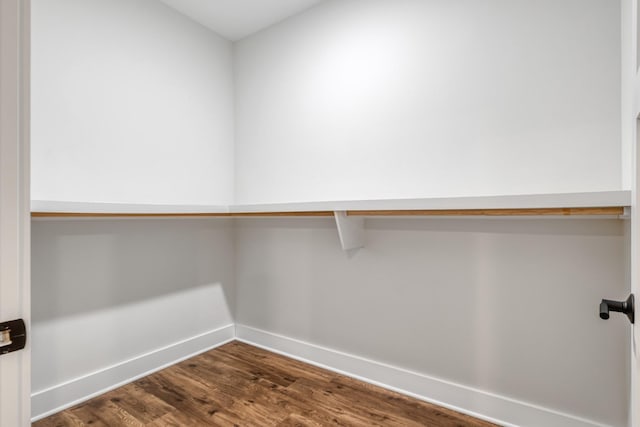 walk in closet with dark wood-type flooring