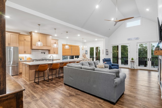 living room featuring french doors, a wealth of natural light, and hardwood / wood-style flooring