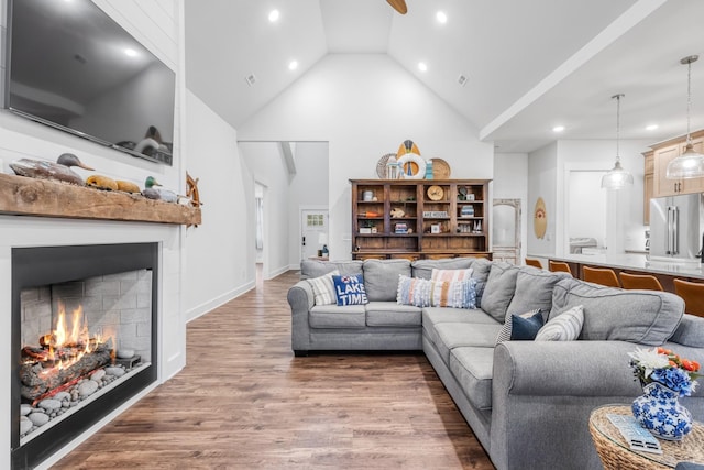 living room featuring ceiling fan, high vaulted ceiling, and wood-type flooring