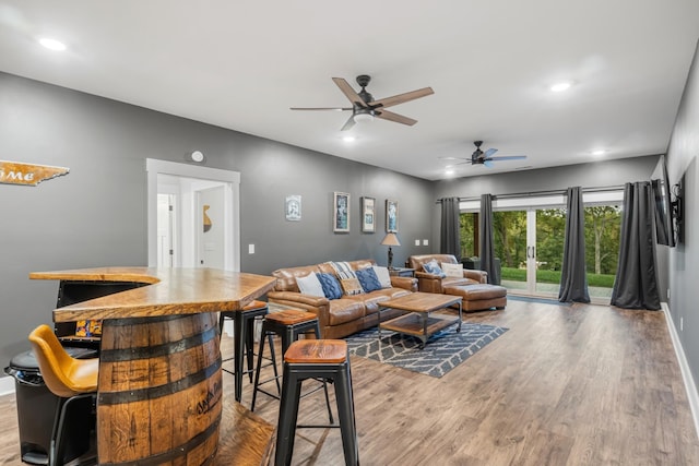 living room with ceiling fan, french doors, and light hardwood / wood-style floors