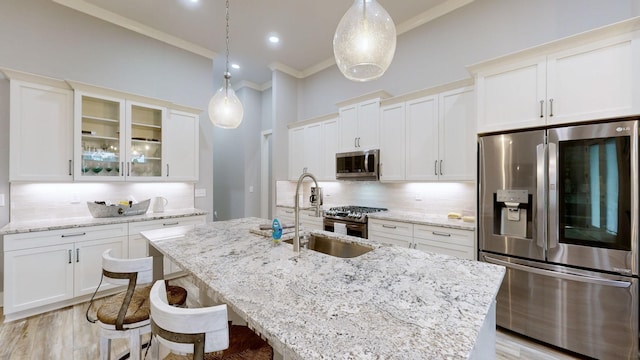 kitchen with sink, appliances with stainless steel finishes, crown molding, and pendant lighting