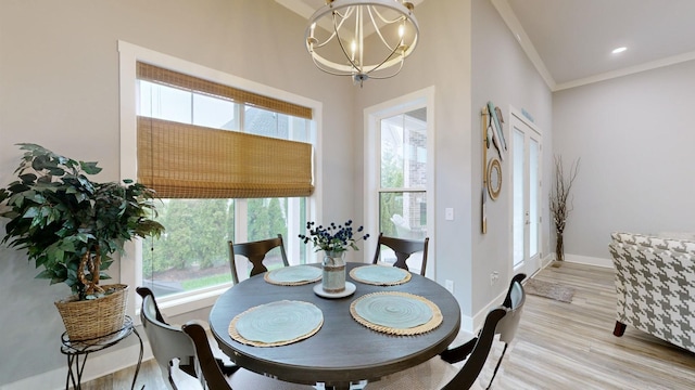 dining space featuring a notable chandelier, light hardwood / wood-style flooring, and crown molding