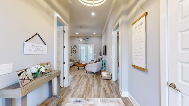 hallway with ornamental molding and light hardwood / wood-style flooring