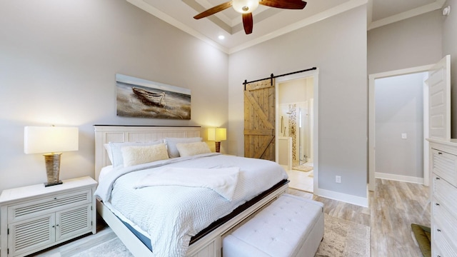 bedroom with light hardwood / wood-style flooring, ensuite bath, ceiling fan, crown molding, and a barn door