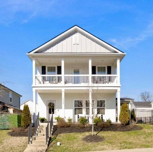 view of front facade with a balcony and a front lawn