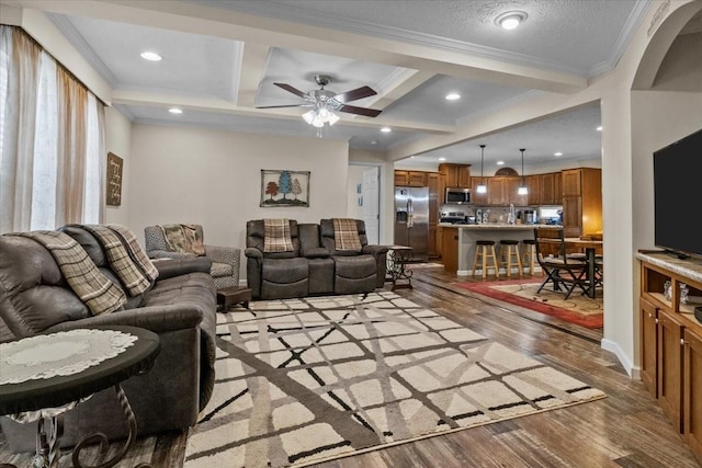 living room featuring light hardwood / wood-style flooring, crown molding, coffered ceiling, and beamed ceiling