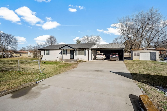 single story home featuring driveway, a garage, a front lawn, and an outbuilding