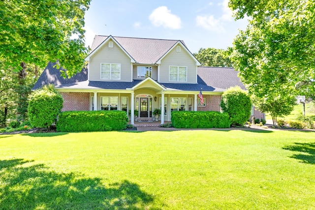 1000 Bradby Dr, Burns, TN 37029 - traditional-style home featuring a front lawn, covered porch, a shingled roof, and brick siding
