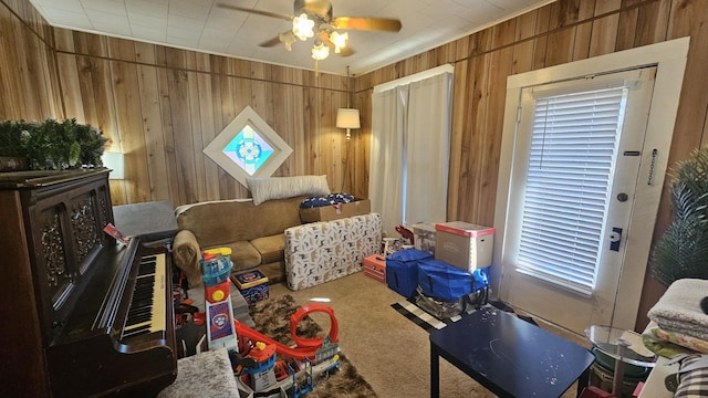 interior space featuring carpet, ceiling fan, and wood walls