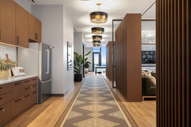 hallway with a wall of windows and light hardwood / wood-style flooring