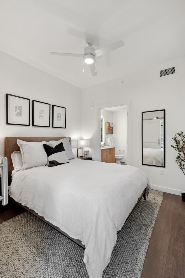 bedroom with ensuite bathroom, ceiling fan, and dark wood-type flooring