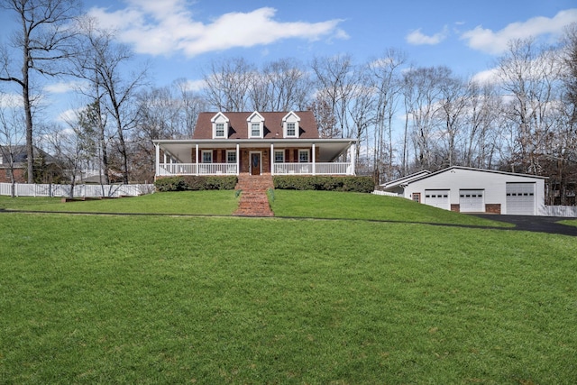 view of front of home featuring a garage, an outbuilding, a front lawn, and a porch