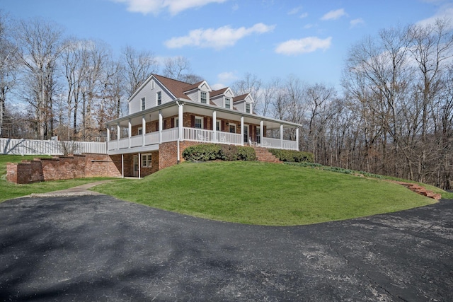 farmhouse-style home featuring covered porch and a front lawn