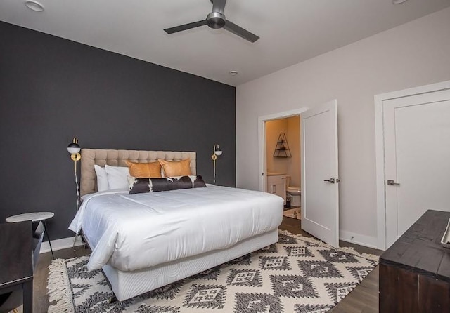 bedroom featuring hardwood / wood-style floors, ceiling fan, and ensuite bath