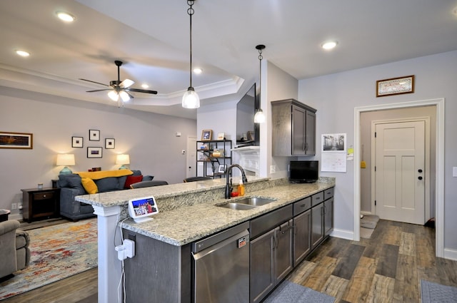kitchen featuring sink, a tray ceiling, light stone counters, dishwasher, and pendant lighting