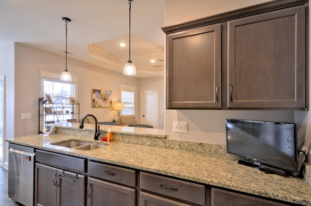 kitchen with hanging light fixtures, dark brown cabinetry, sink, and stainless steel dishwasher