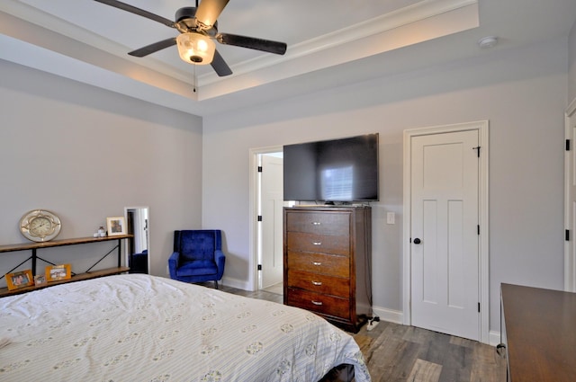 bedroom featuring dark hardwood / wood-style flooring, ceiling fan, and a raised ceiling