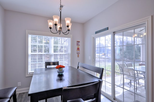 dining area with a chandelier, wood-type flooring, and a wealth of natural light