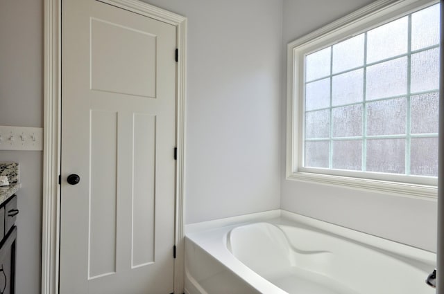 bathroom featuring a washtub and vanity