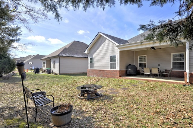 rear view of house featuring a patio area, a lawn, ceiling fan, and a fire pit
