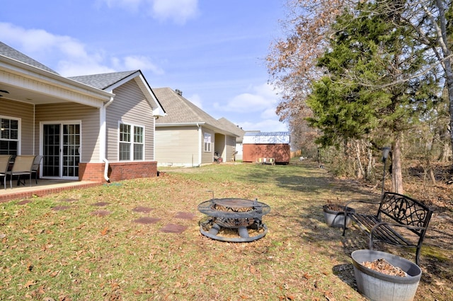view of yard with an outdoor fire pit and a storage unit