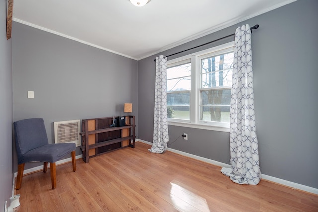 sitting room featuring baseboards, ornamental molding, and light wood finished floors