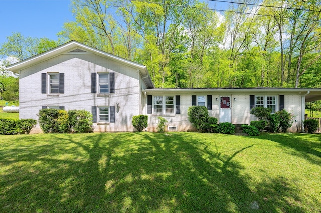 split level home with a front yard and brick siding