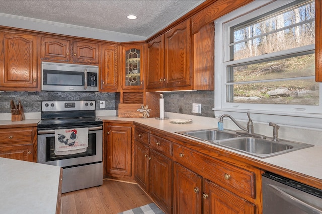 kitchen featuring light countertops, a textured ceiling, appliances with stainless steel finishes, and a sink