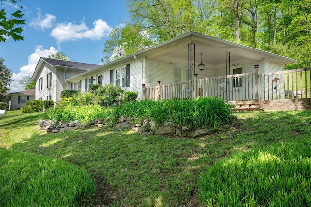 view of side of property featuring a lawn and brick siding