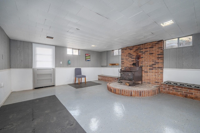 interior space featuring a wood stove and wooden walls