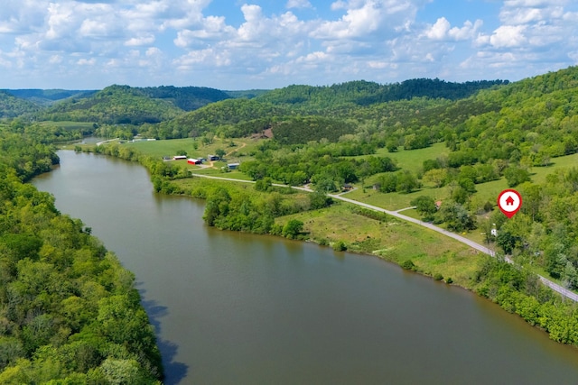 drone / aerial view featuring a water view and a wooded view