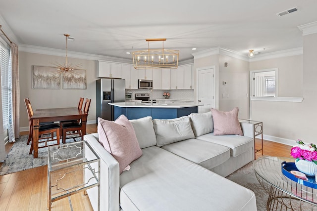 living room featuring a wealth of natural light, crown molding, and light hardwood / wood-style floors