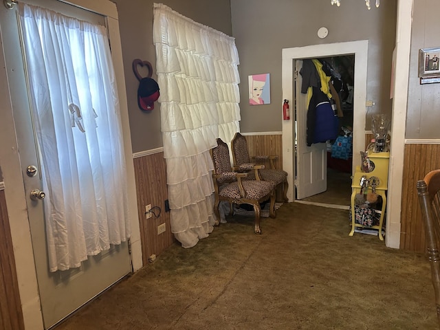 hallway with a wainscoted wall and wooden walls