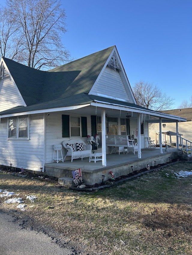 view of front of home with covered porch and a front lawn