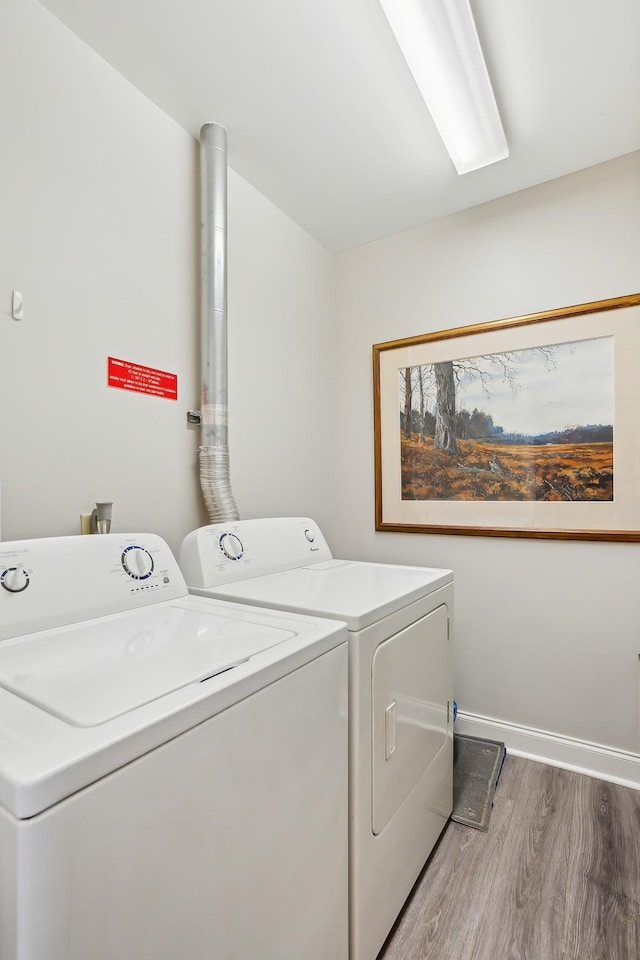 laundry area featuring washing machine and dryer and hardwood / wood-style floors