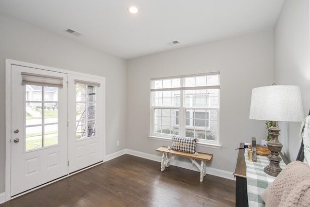 entryway featuring dark wood-type flooring, a healthy amount of sunlight, visible vents, and baseboards