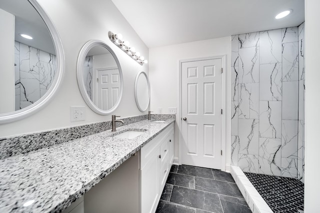 bathroom with tiled shower and vanity