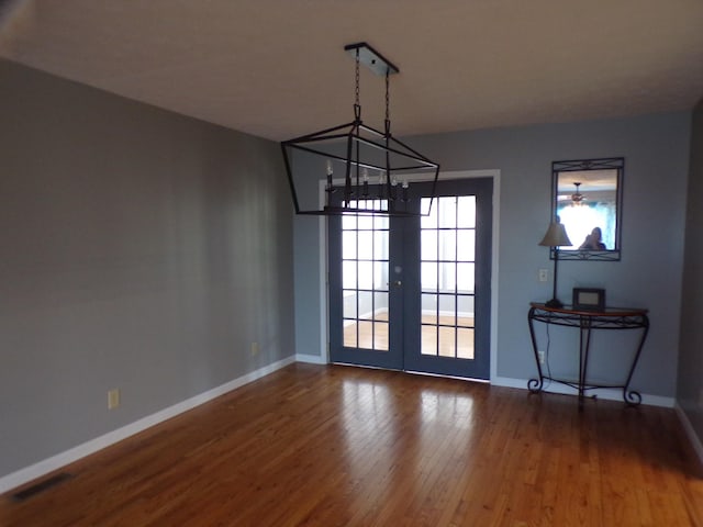 unfurnished dining area featuring french doors and hardwood / wood-style flooring