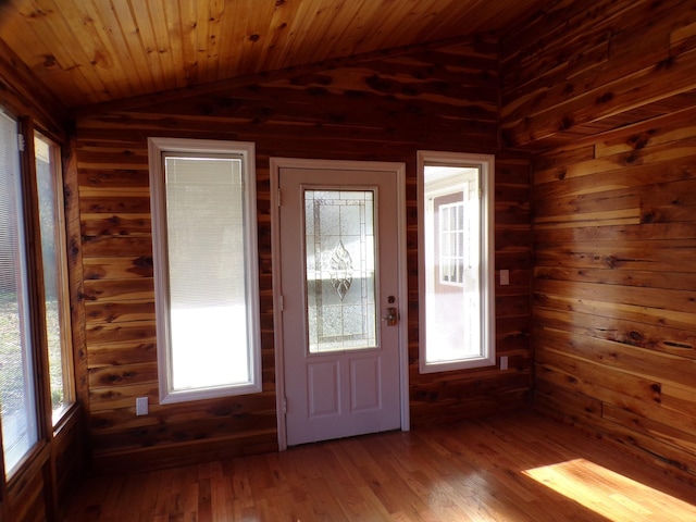 entryway with wooden walls, hardwood / wood-style floors, wood ceiling, and lofted ceiling