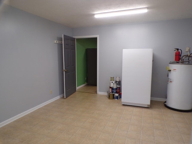 unfurnished room featuring water heater and a textured ceiling