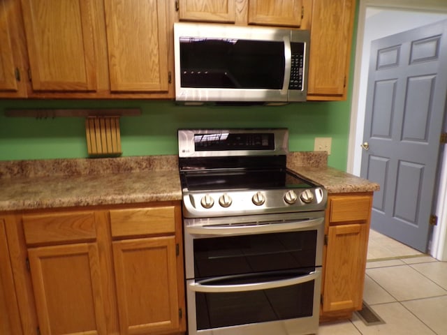 kitchen with stainless steel appliances and light tile patterned floors