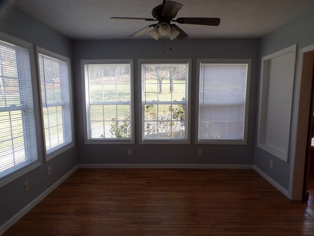 unfurnished sunroom with ceiling fan