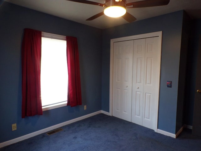 unfurnished bedroom with carpet, a closet, and ceiling fan