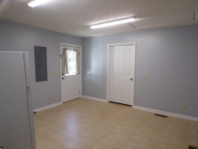 unfurnished room featuring electric panel and a textured ceiling